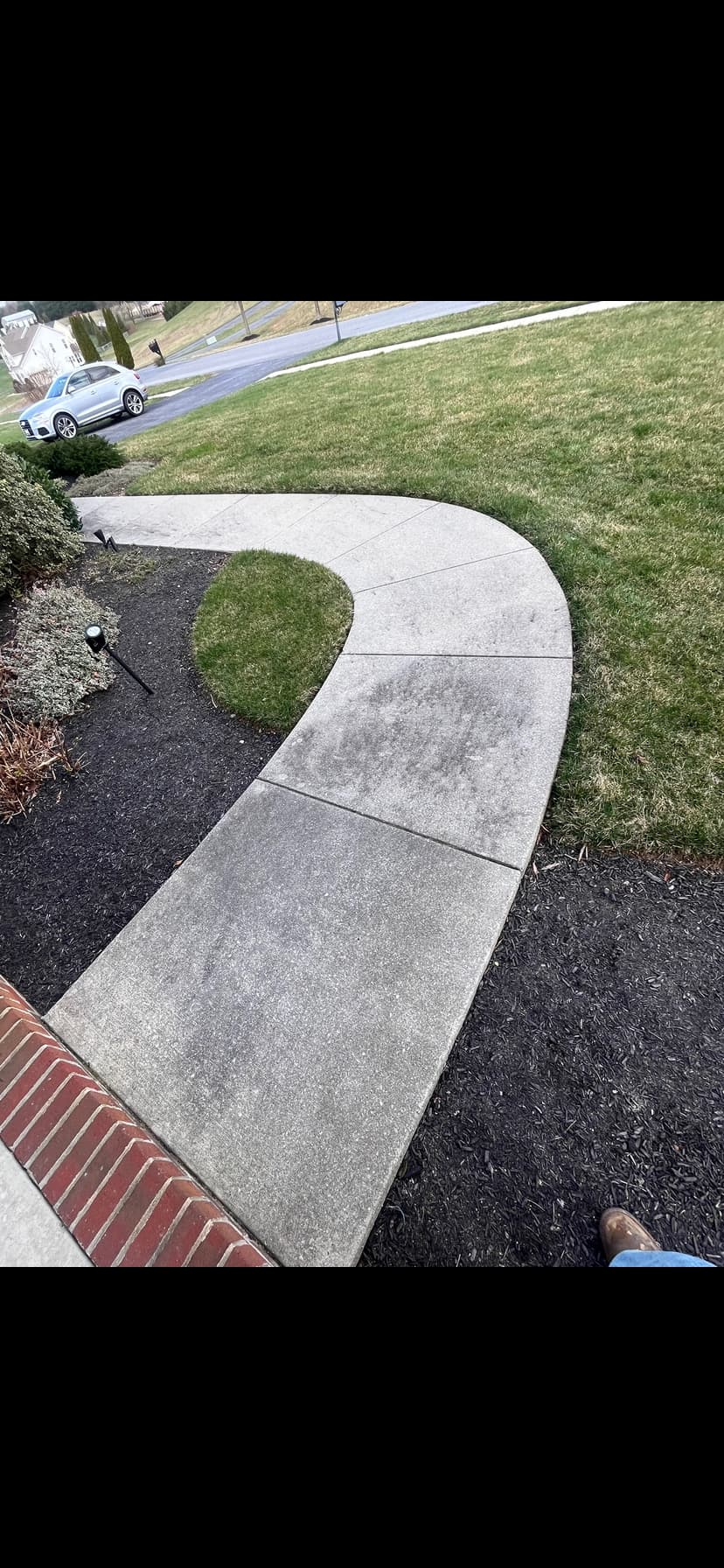 Curved concrete walkway pressure wash — before